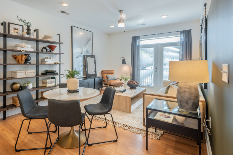 a living room with a table and chairs and a window