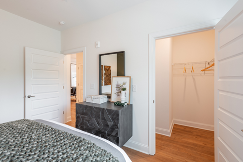 a bedroom with a bed and a dresser with a mirror