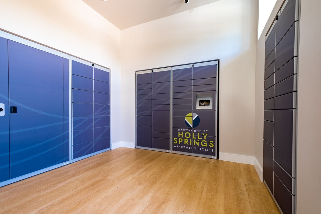 a hallway with blue lockers and a door to the holy springs conference room