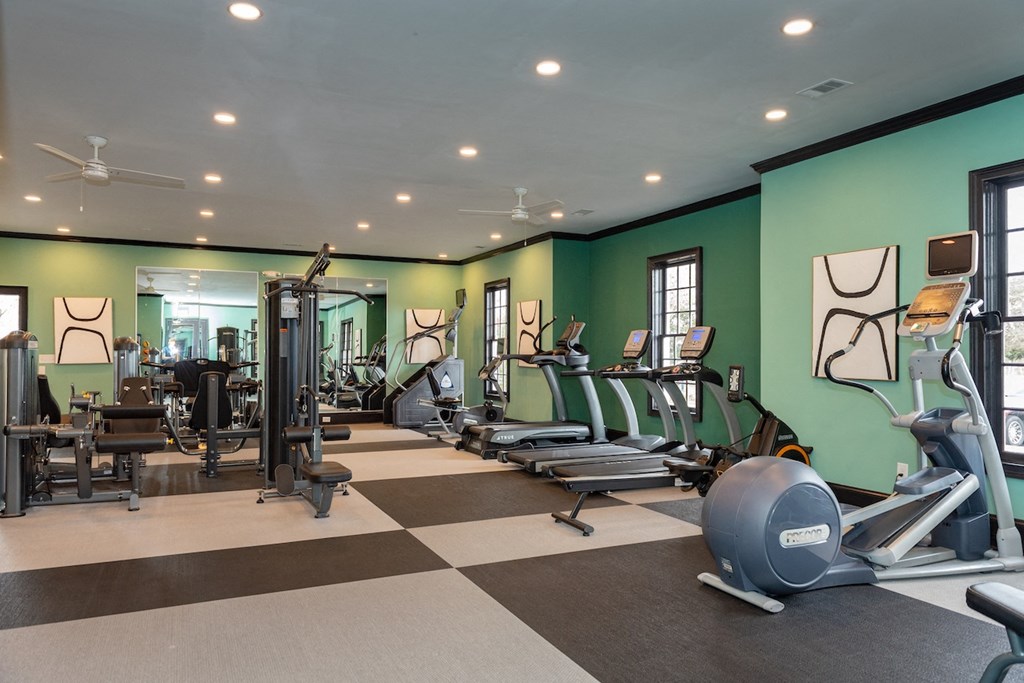 Amenities a gym with cardio equipment and weights on a checkered floor