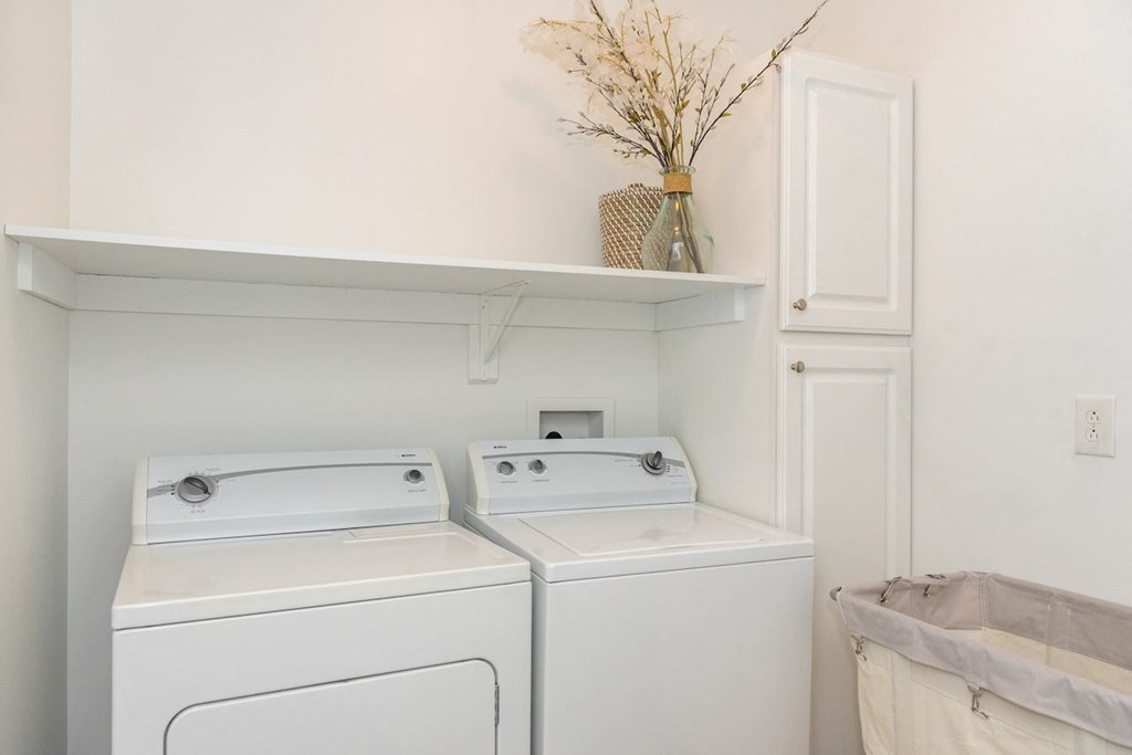 a white washer and dryer in a white laundry room
