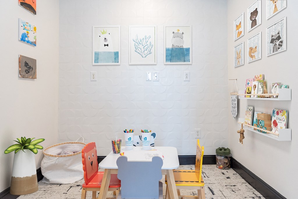 a table and chairs in front of a white wall with pictures on it