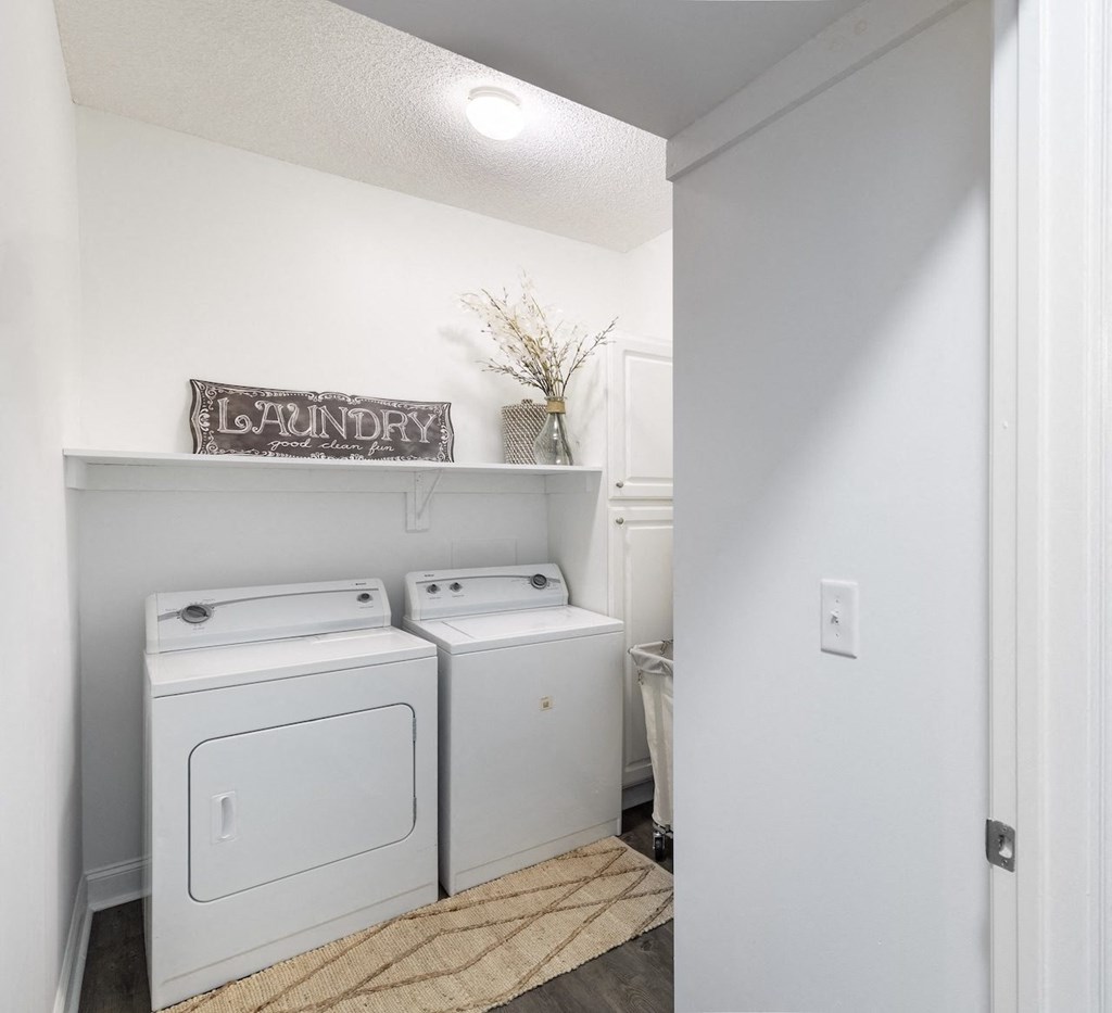 a white washer and dryer in a small laundry room with a white door