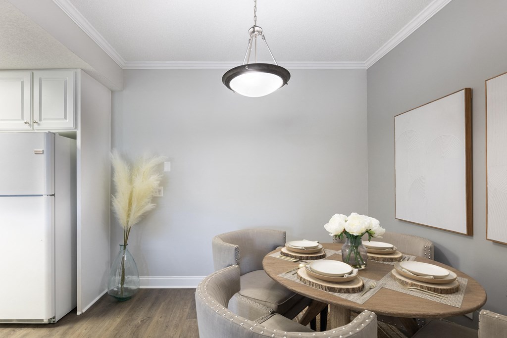 a dining room with a table and chairs and a refrigerator