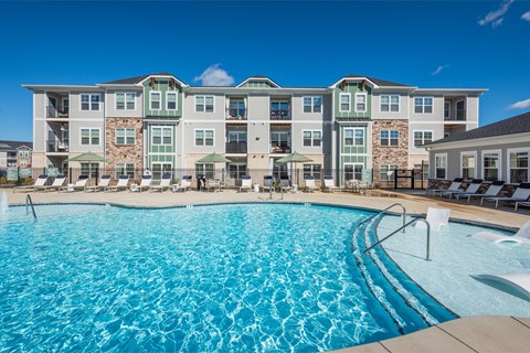 a swimming pool with an apartment building in the background