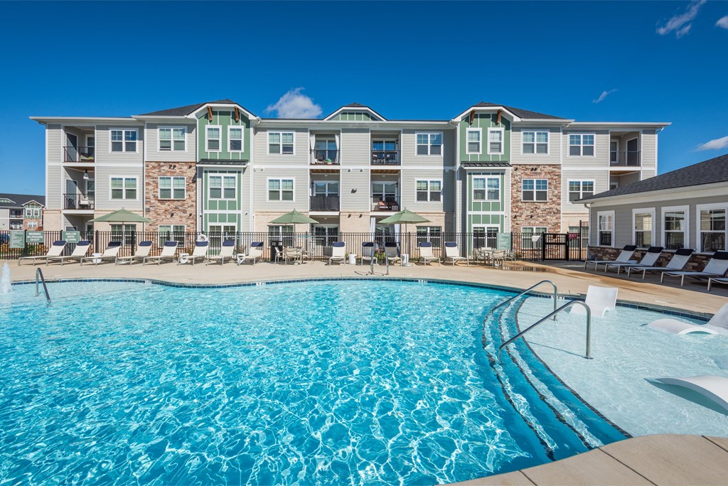 a swimming pool with an apartment building in the background