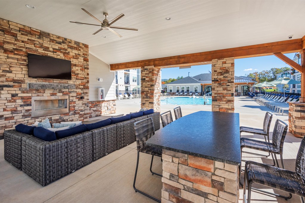 the clubhouse with a pool and a table with chairs and a tv