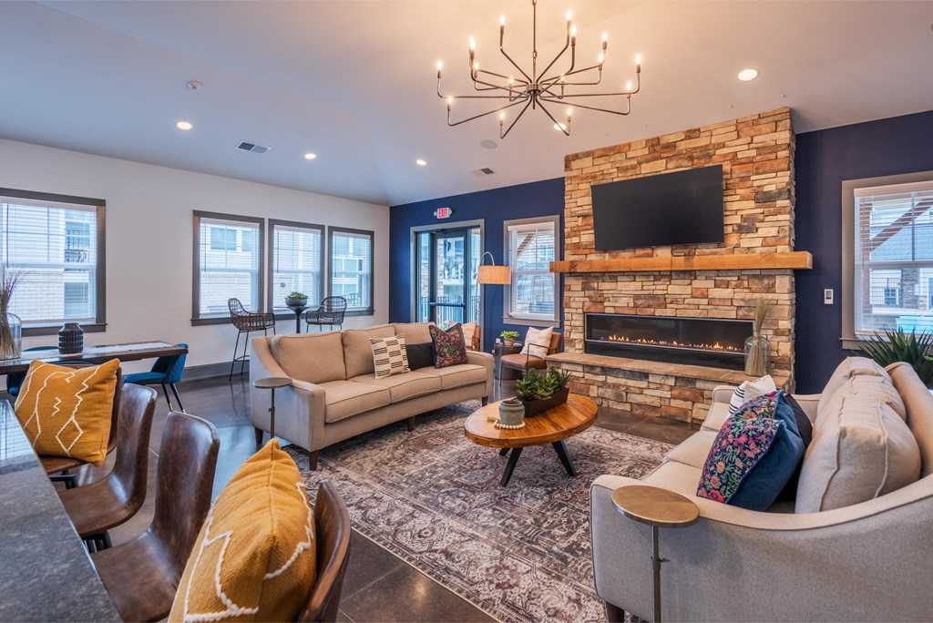 a living room with couches and a fireplace and a chandelier