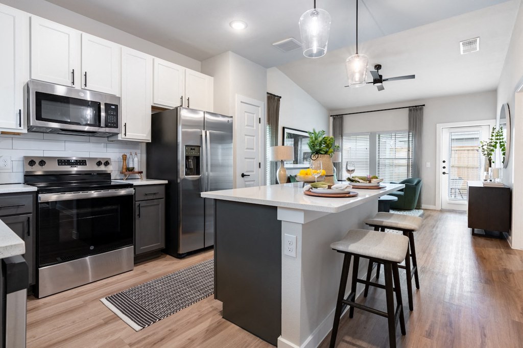 A modern kitchen with stainless steel appliances and a central island.