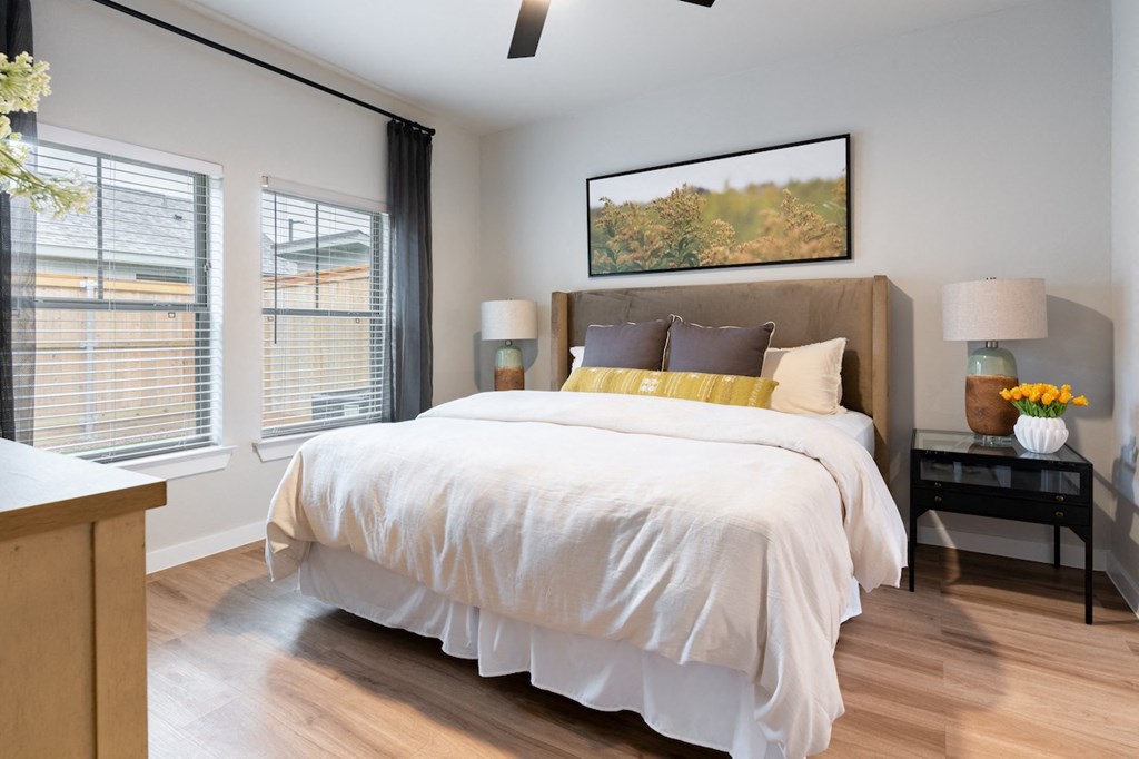 A bedroom with a large bed and a painting on the wall.