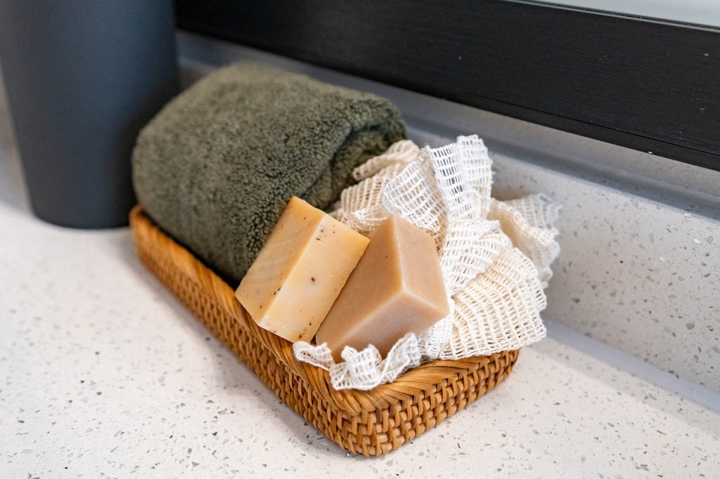 A basket of soaps and towels on a bathroom counter.