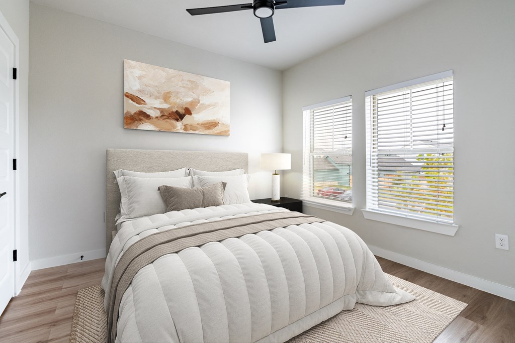 A bedroom with a large bed and a ceiling fan.