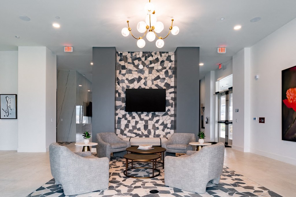 A living room with a grey and white checkered wallpaper and a black and white patterned rug.