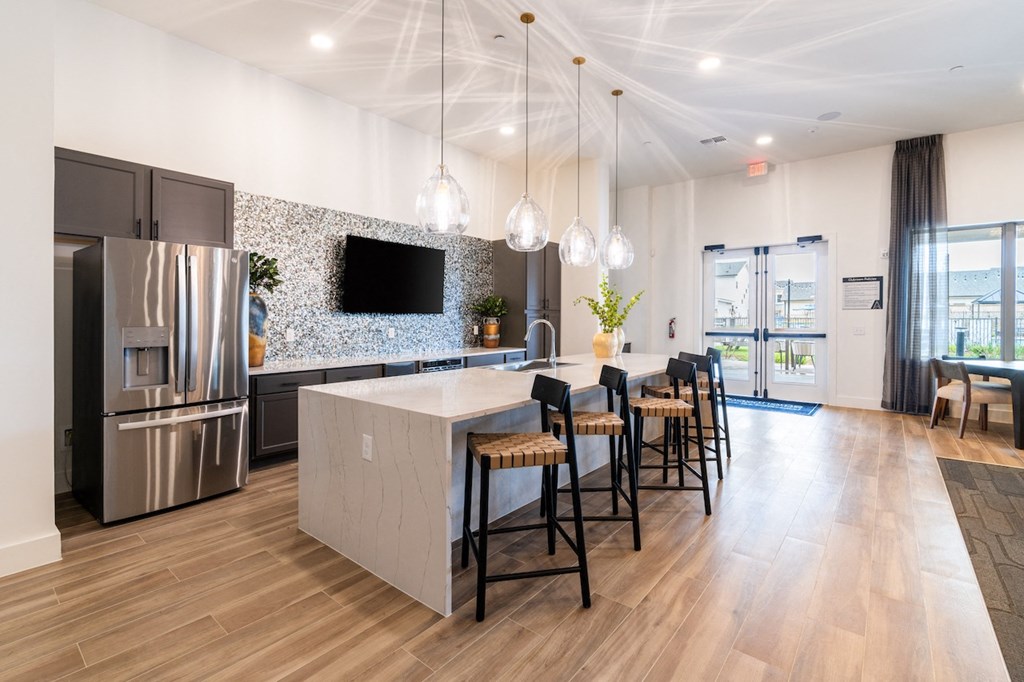 A modern kitchen with a marble island and stainless steel appliances.