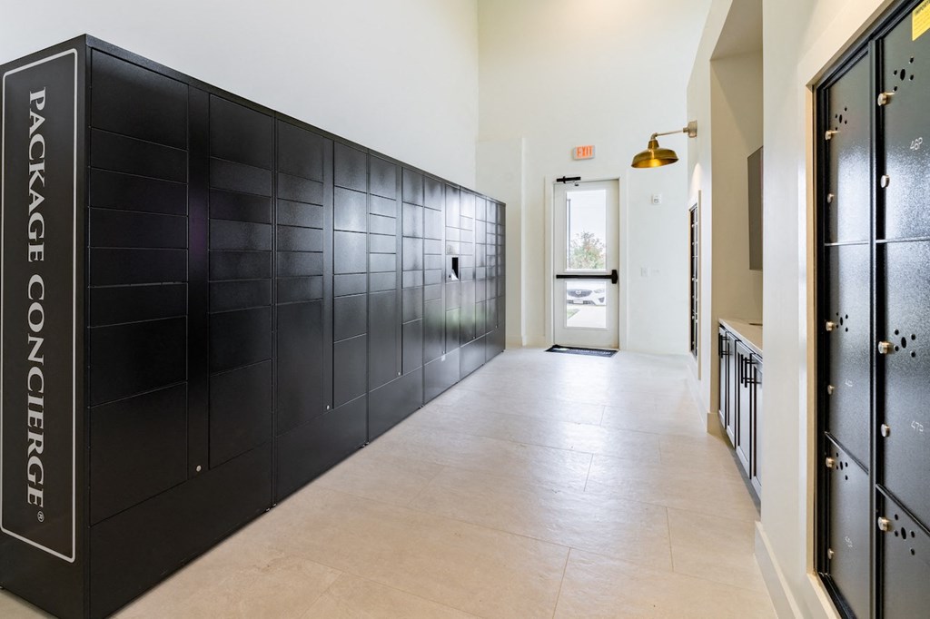 A long hallway with a black wall on the left side that says Package Concierge.