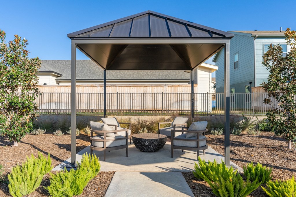 A patio with a table and chairs under a canopy.