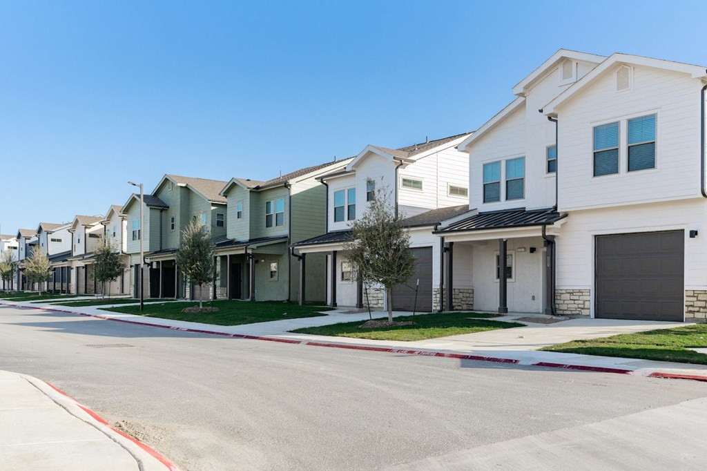 A row of houses with garages and driveways.