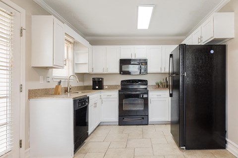 a kitchen with black appliances and white cabinets