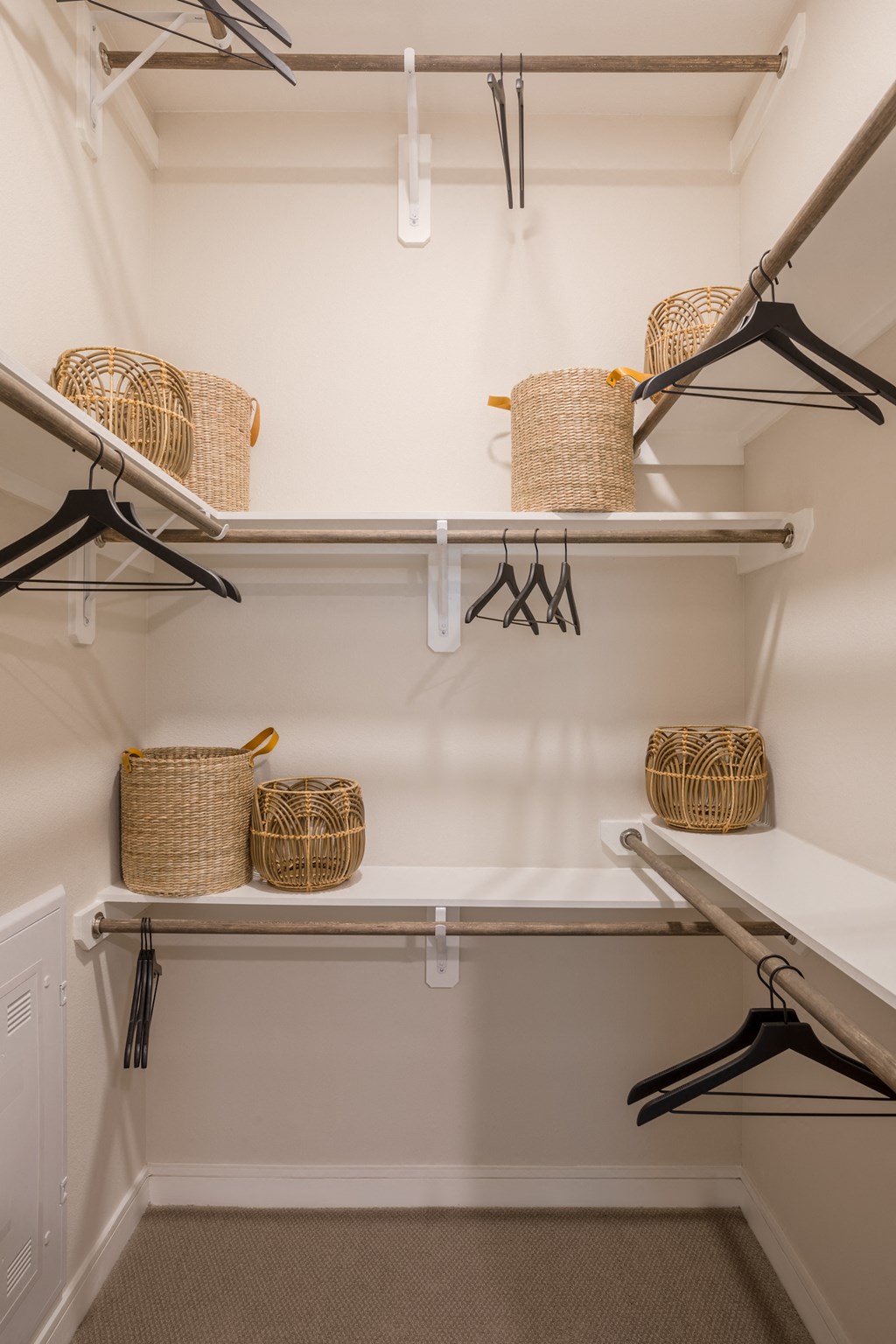 A white closet with three shelves and baskets on them at 27Seventy Lower Heights apartments in Houston, TX.
