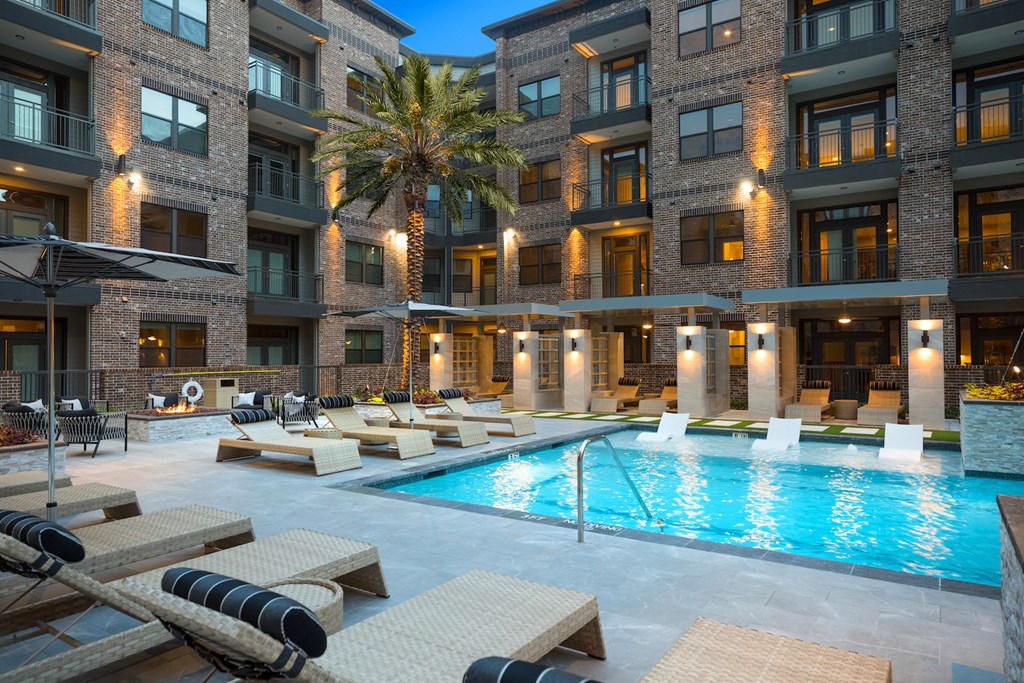 A large apartment building with a pool in front at 27Seventy Lower Heights apartments in Houston, TX.