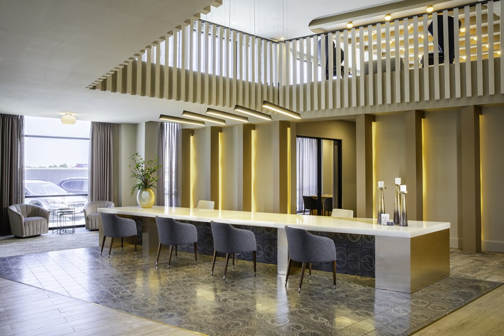 A reception area with a long table and chairs at 27Seventy Lower Heights apartments in Houston, TX.
