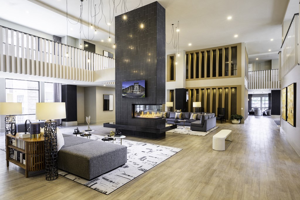 A modern clubhouse with a fireplace and a television on the wall at 27Seventy Lower Heights apartments in Houston, TX.