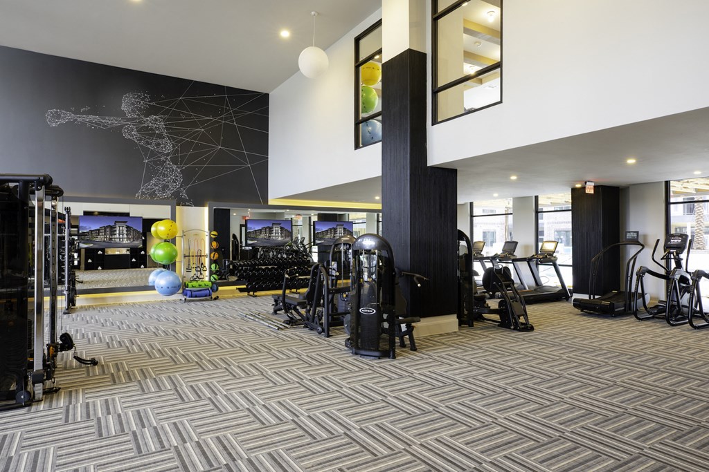 A gym with a variety of equipment including treadmills, weights, and exercise balls at 27Seventy Lower Heights apartments in Houston, TX.