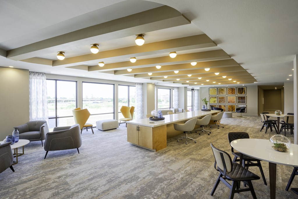 A common room with a variety of seating options and a long table at 27Seventy Lower Heights apartments in Houston, TX.