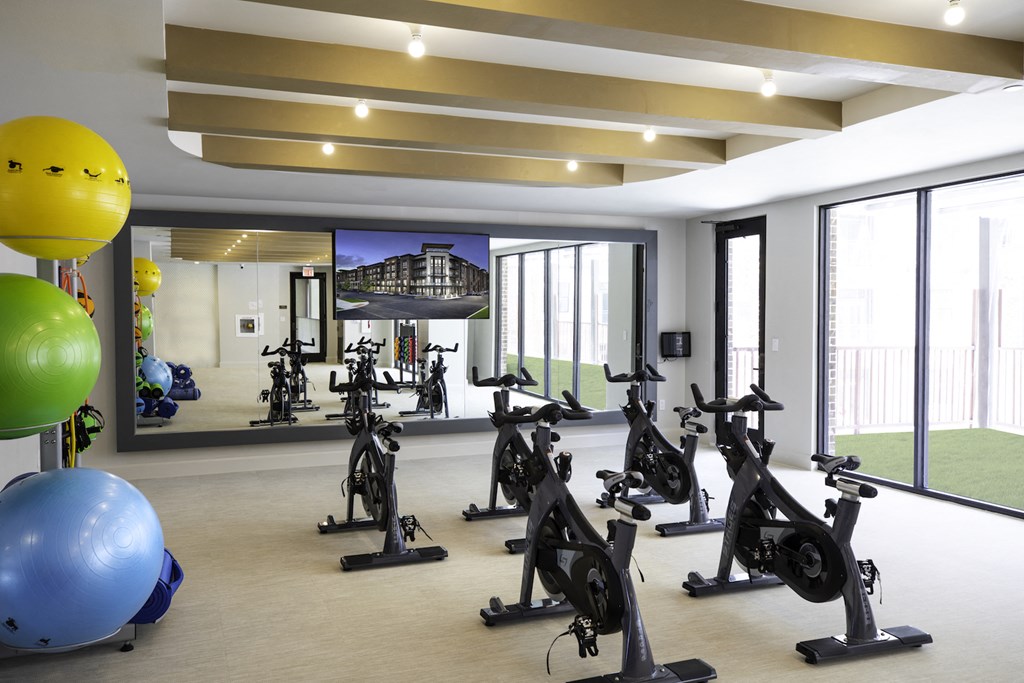 A gym with exercise bikes and exercise balls at 27Seventy Lower Heights apartments in Houston, TX.