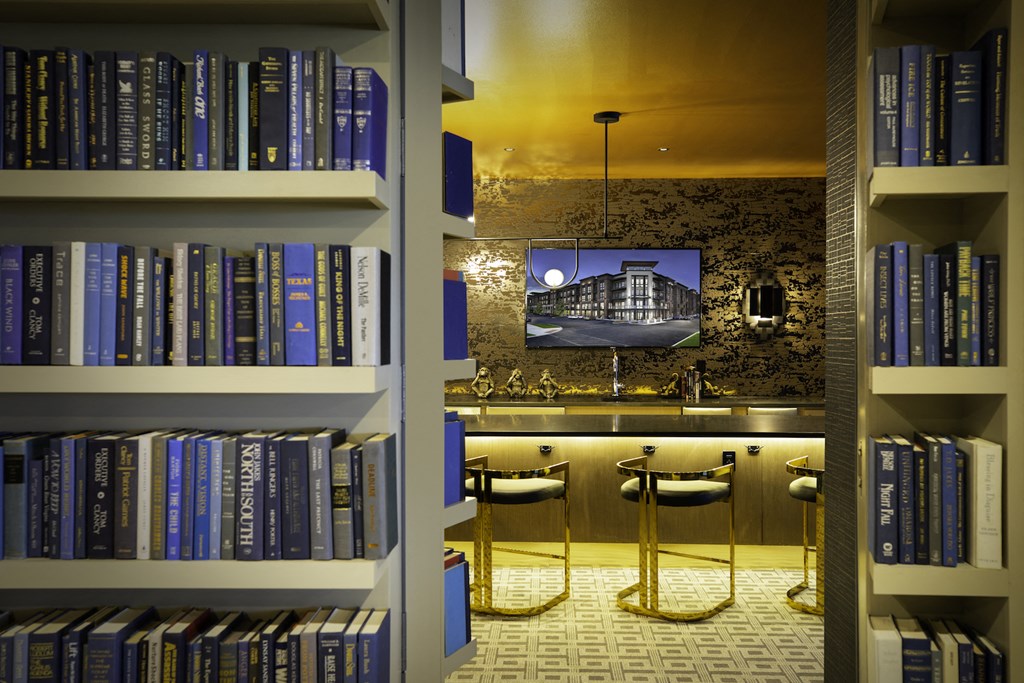 A bookshelf filled with books and a seating area at 27Seventy Lower Heights apartments in Houston, TX..