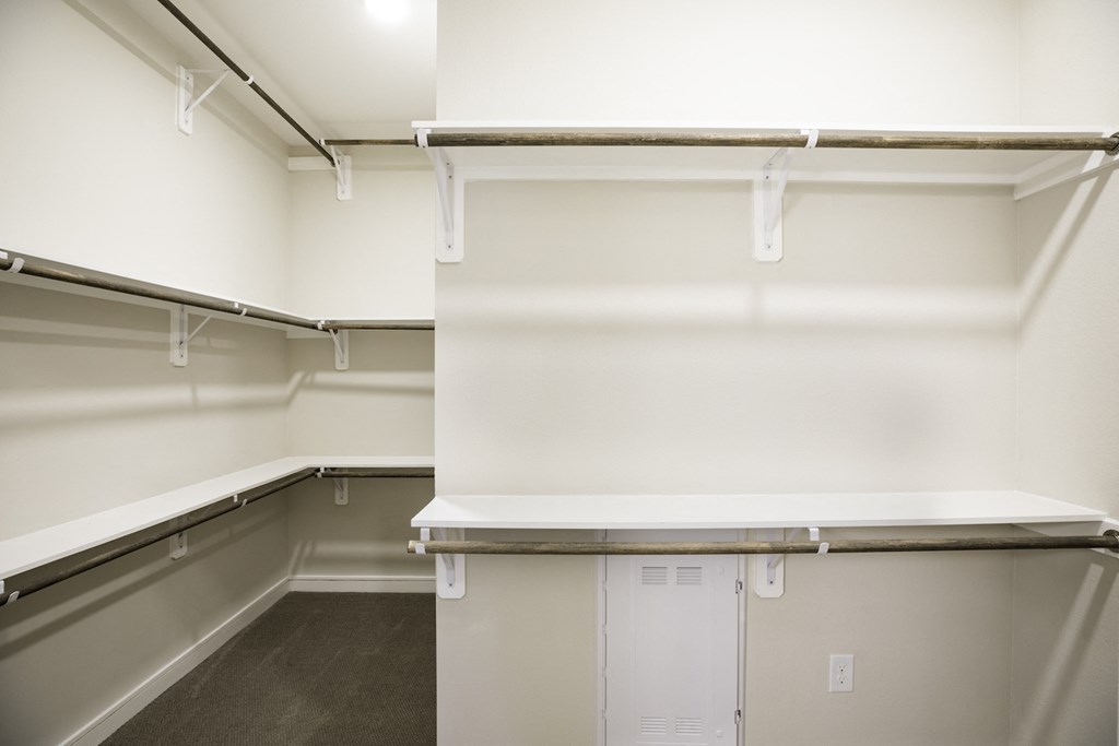 Empty white shelves in a walk in closet at 27Seventy Lower Heights apartments in Houston, TX.