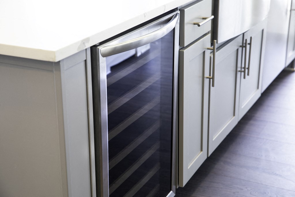A kitchen with a white counter top and a stainless steel built in wine fridge at 27Seventy Lower Heights apartments in Houston, TX.