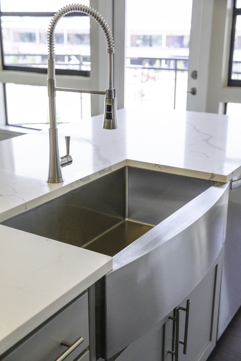 A kitchen sink with a chrome faucet and a marble style countertop at 27Seventy Lower Heights apartments in Houston, TX.