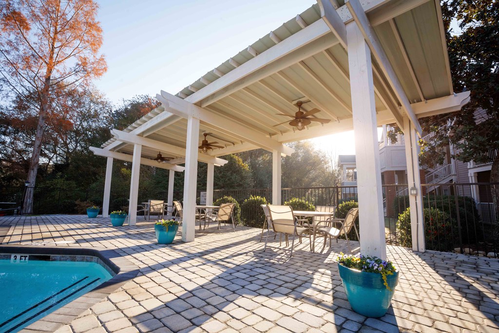 a patio with a pool and a covered pavilion
