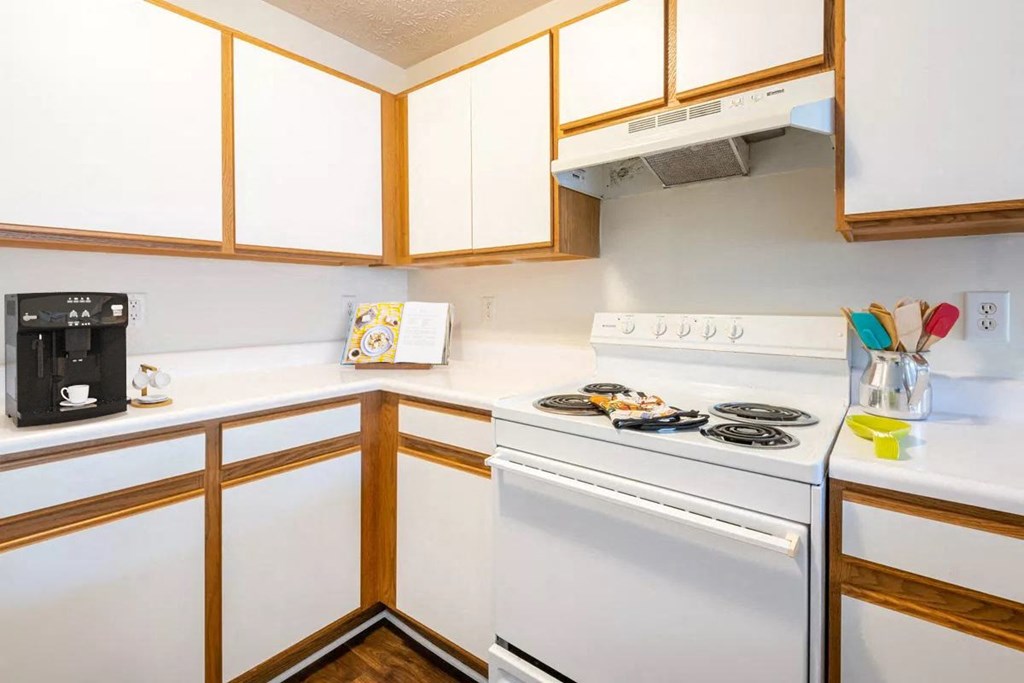 a kitchen with white appliances and wooden cabinets
