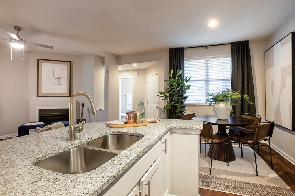 an open kitchen and living room with a sink and a table