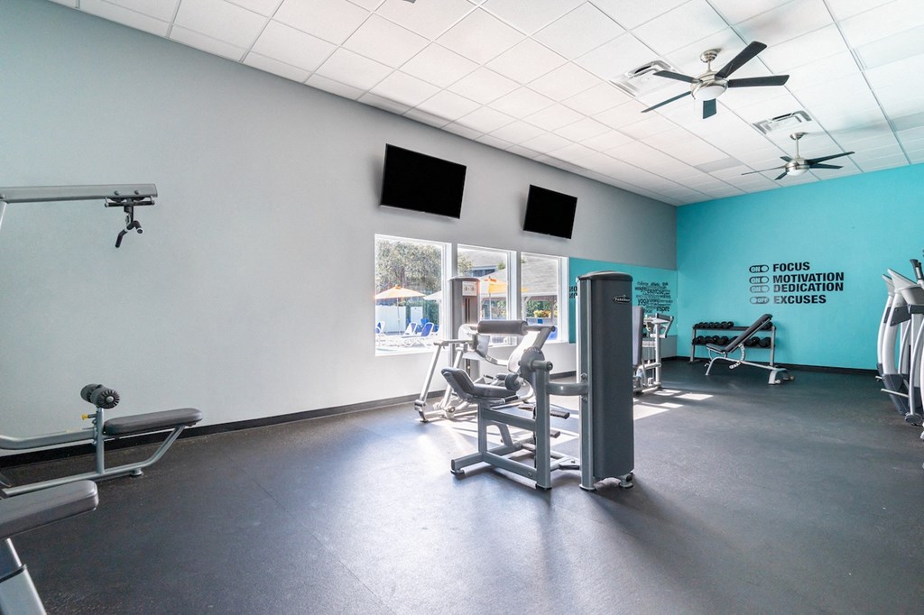 a fitness room with treadmills and other exercise equipment