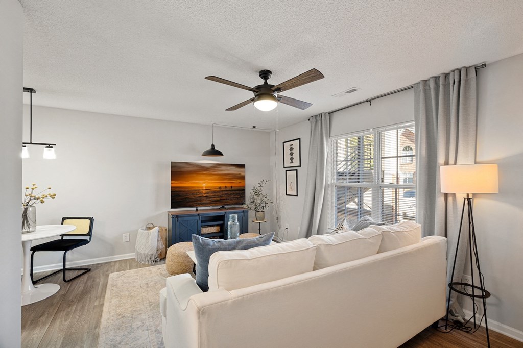 a living room with a couch and a ceiling fan
