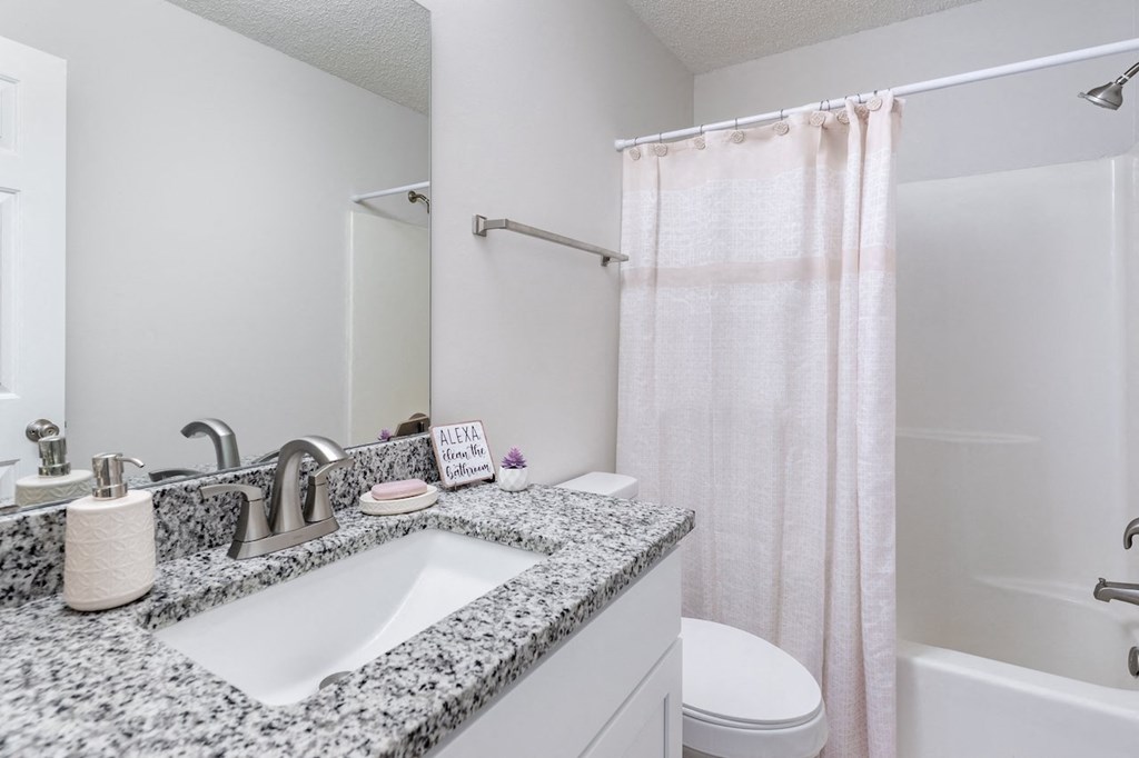 A bathroom with a sink, toilet, and shower.