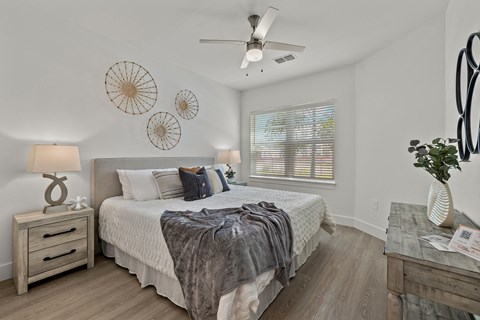 a bedroom with a large bed and a ceiling fan