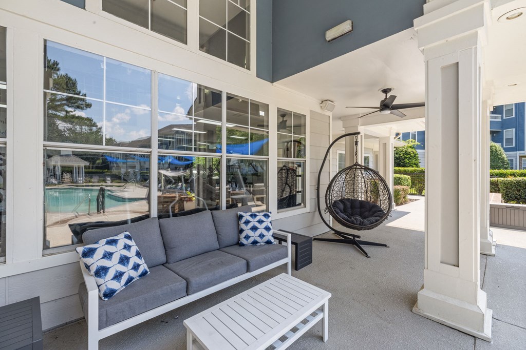 a porch with a couch and a rocking chair and large windows