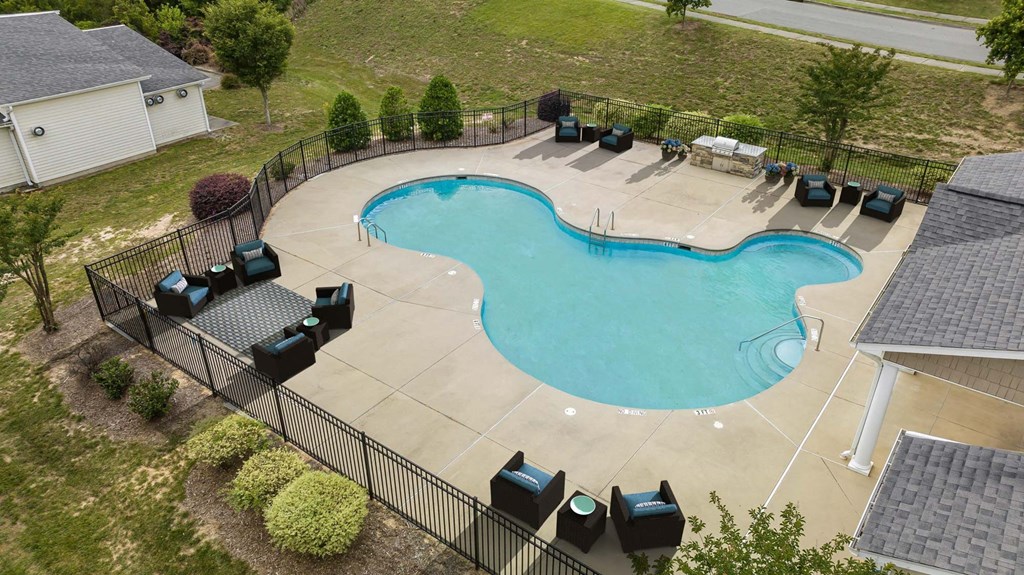 an overhead view of an empty swimming pool in a backyard with tables and chairs