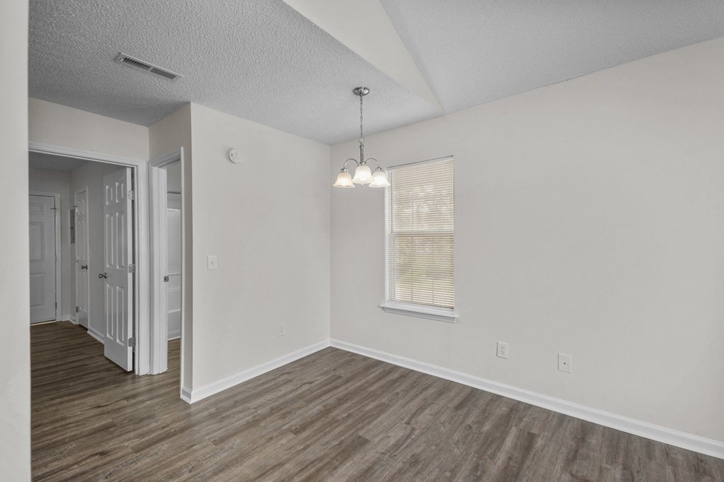 an empty living room with white walls and a window