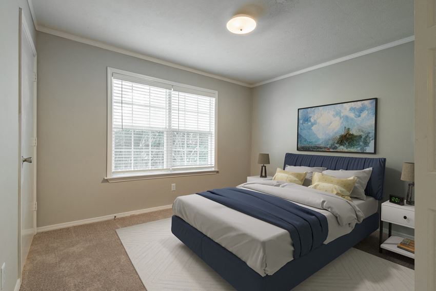 a bedroom with a large bed and two windows