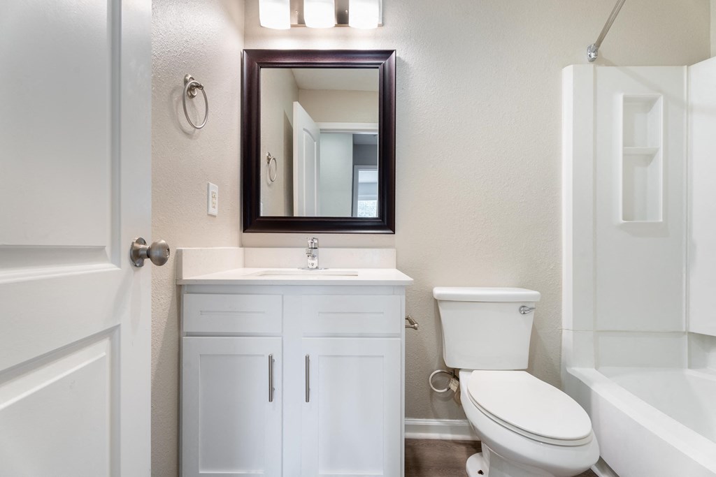 a bathroom with a toilet sink and a mirror