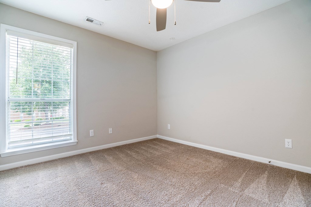 an empty room with carpet and a large window