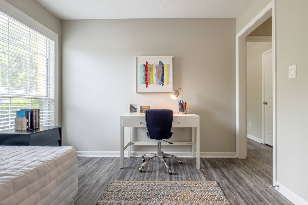 a bedroom with a desk and chair in a 555 waverly unit