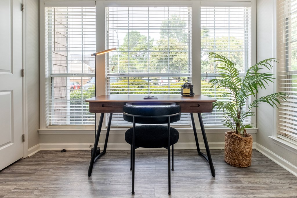 a home office with a desk and chair in front of a window