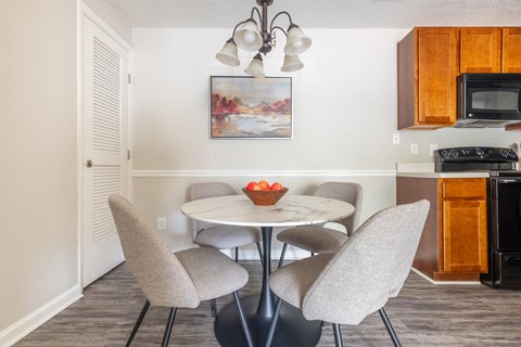 a kitchen and dining area with a table and chairs and a microwave