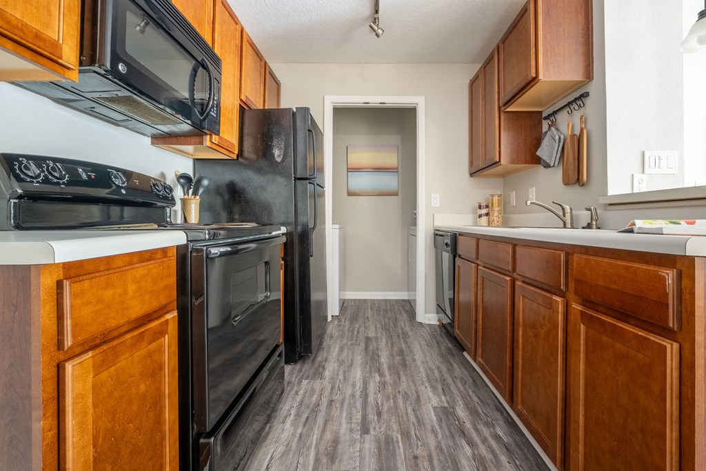 a kitchen with wood cabinets and black appliances